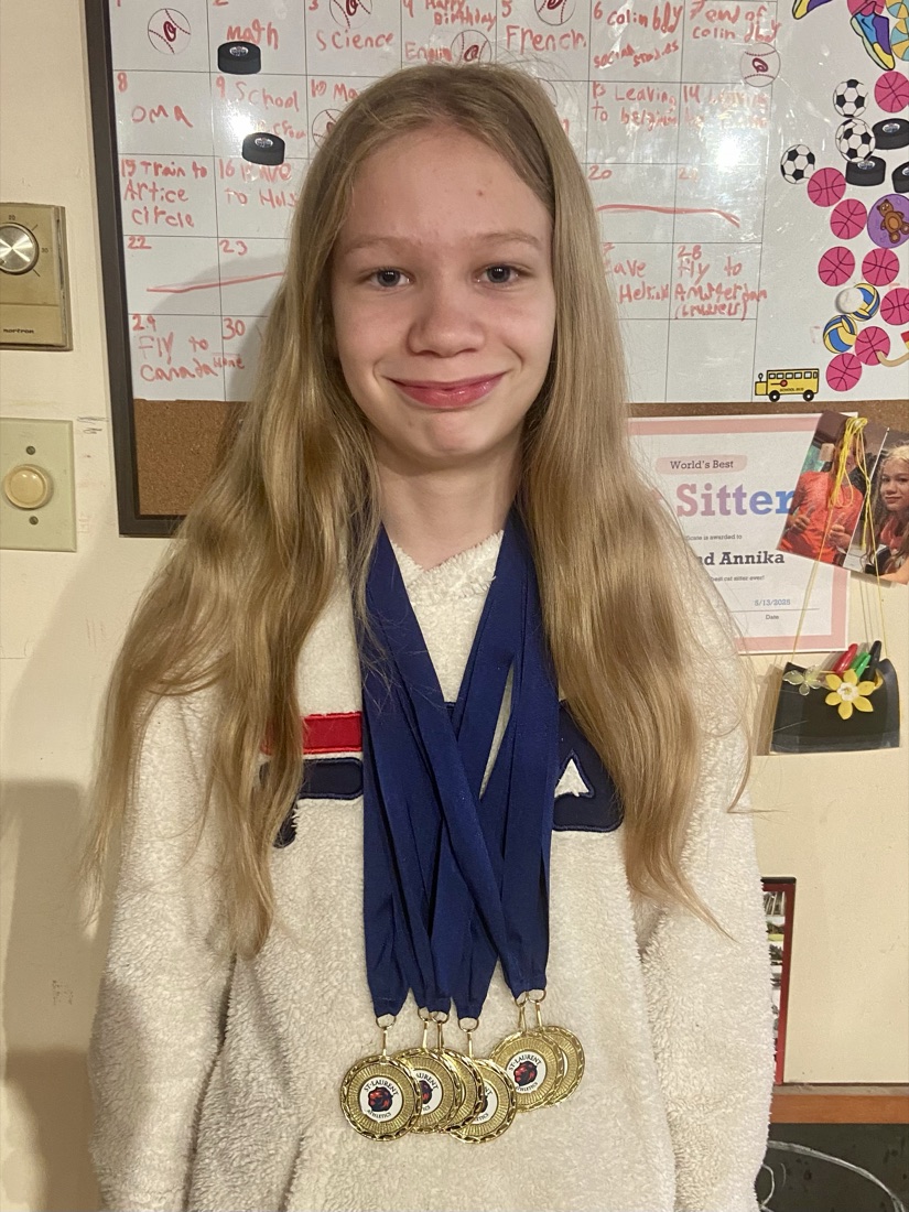 Annika wearing a stack of gold basketball medals